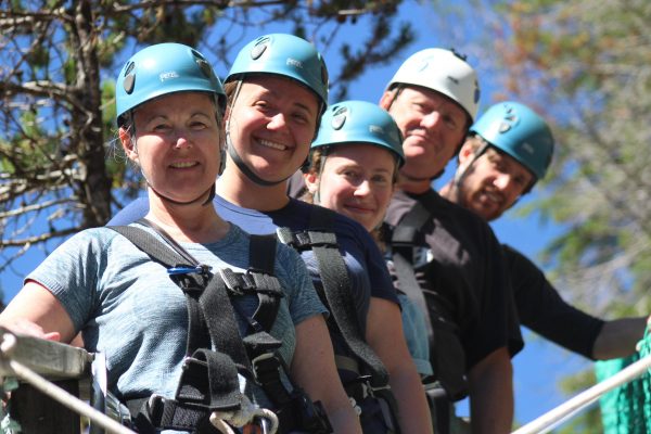 Friends smiling while getting ready to zip-line