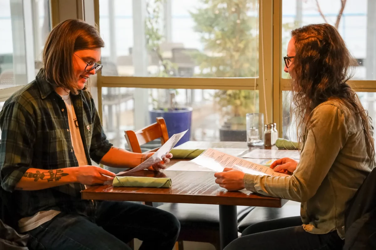 Couple seated at a restaurant table in Port Alberni, reading menus and enjoying a quiet Valentine’s Day meal