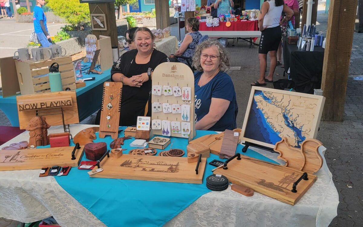 Local vendors selling handmade goods at a Port Alberni market with shoppers browsing artisan products