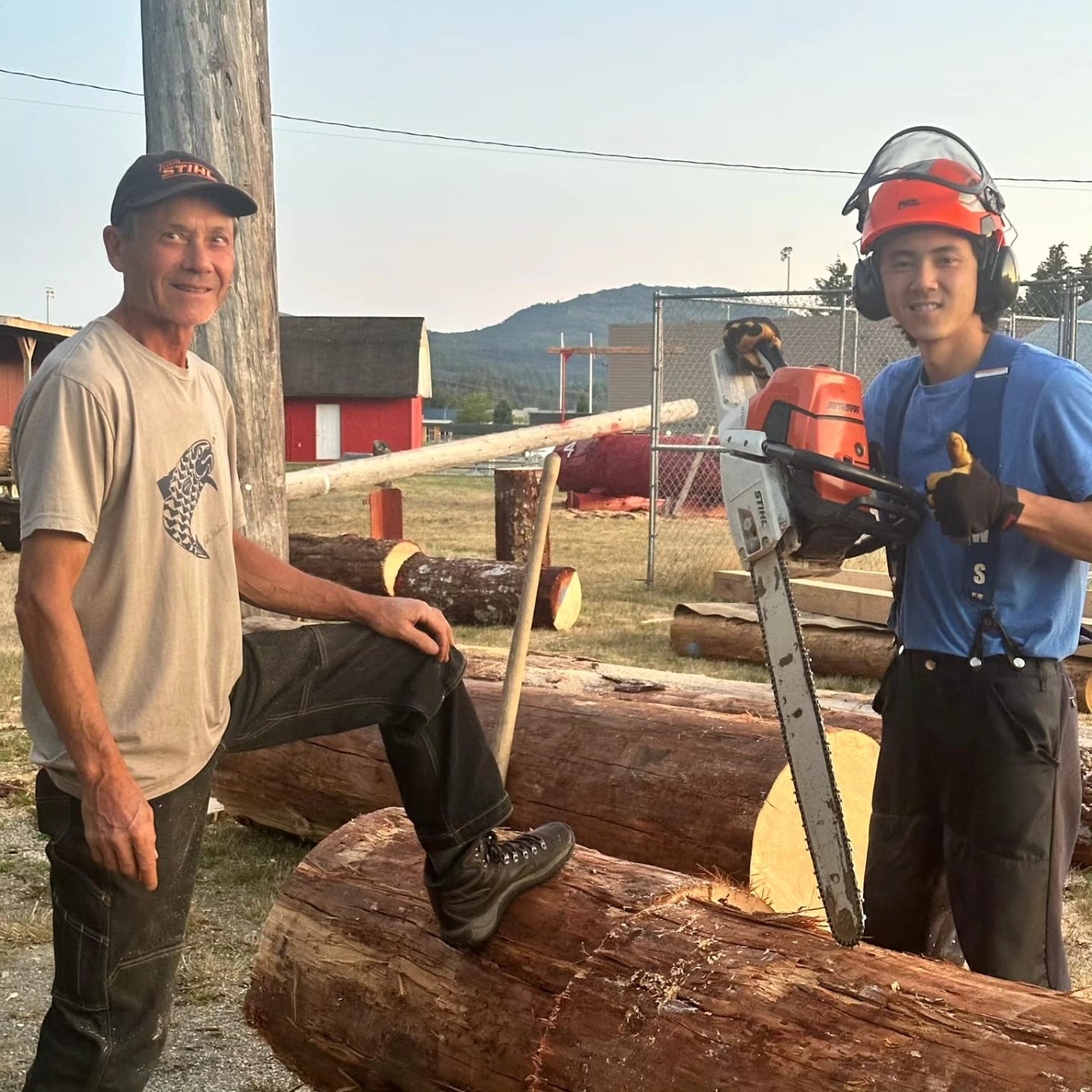 Two men preparing logs for logger sports at the Alberni District Fall Fair fairgrounds