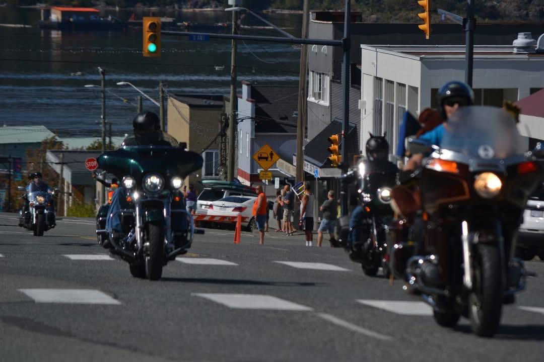 Row of motorcycles descending toward the waterfront during the Port Alberni Toy Run parade.