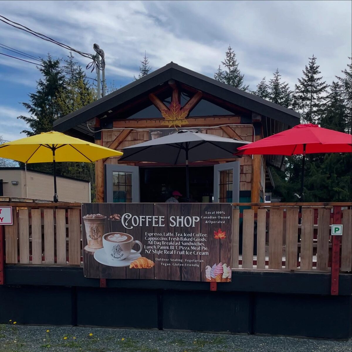The Barkley Café Port Alberni location with outdoor patio, colorful umbrellas, and rustic West Coast cabin-style exterior.