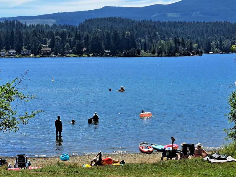 People swimming and relaxing along the beach at Sproat Lake Provincial Park