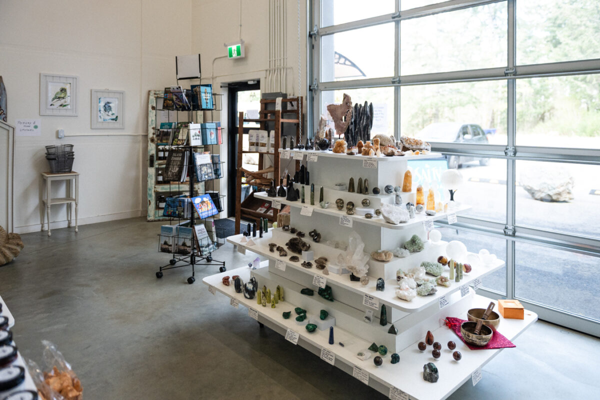 Retail space with concrete floors, wide pathways, and displays of art, goods, and products.