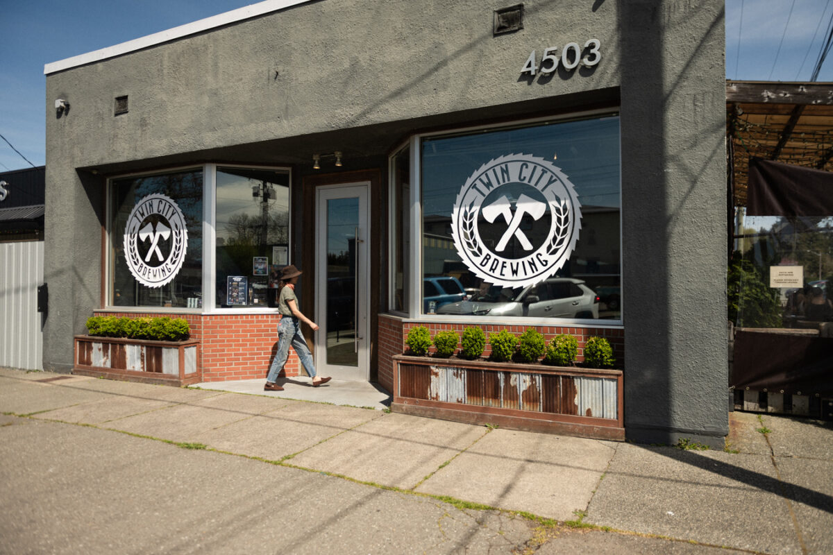 Brewery entrance with a very low door threshold and a manual door with a full-length vertical handle.