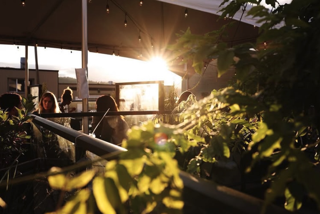 Guests enjoying the patio at Brie & Barrel during golden hour in Port Alberni.